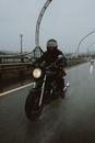 一名孤独的骑手骑着摩托车，在雨天的现代化高速公路桥上行驶