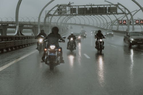 People Riding Motorcycles on a Rainy Day