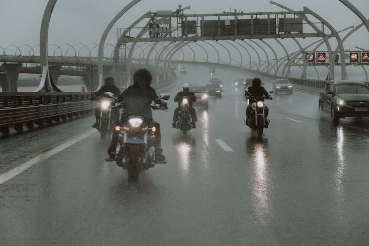 People Riding Motorcycles On A Rainy Day