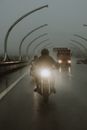 两名摩托车手在雨中高速公路上骑行，前灯照亮了潮湿的路面
