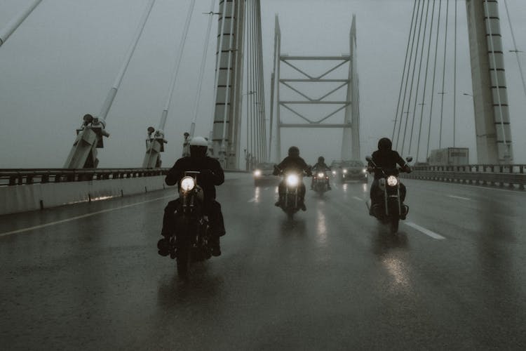 Grayscale Photo Of A Group Of People Riding Motorbikes On A Bridge