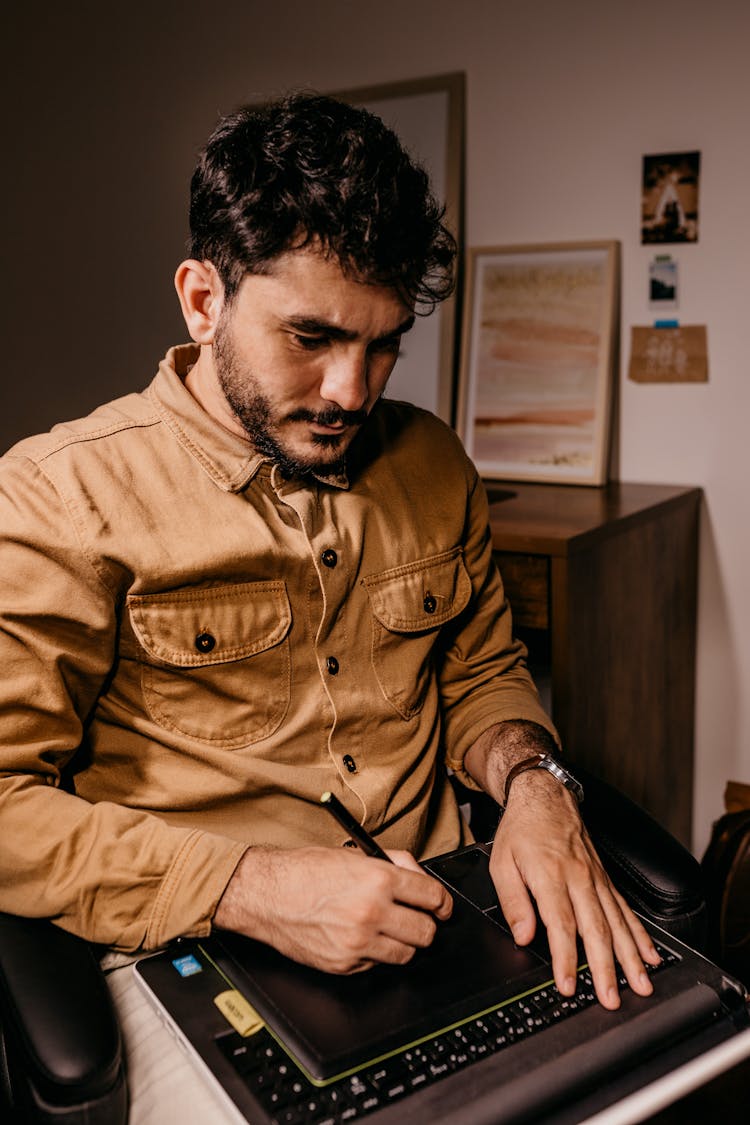 Ethnic Man Working On Laptop And Drawing On Graphic Tablet