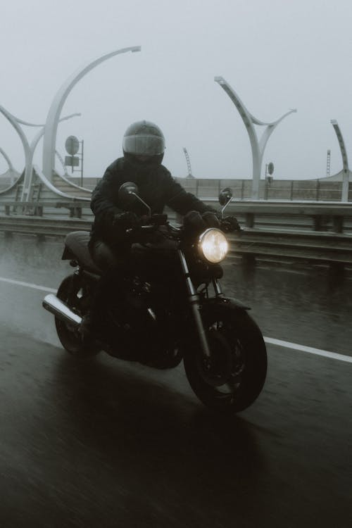 A Man in Black Jacket Riding a Black Motorcycle