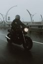 一名摩托车手冒雨在潮湿的高速公路上骑行，展现了交通的韧性