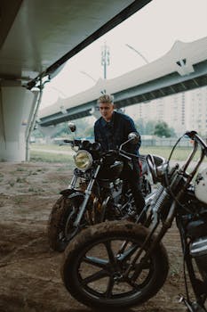 阴天，摩托车手停在城市桥下