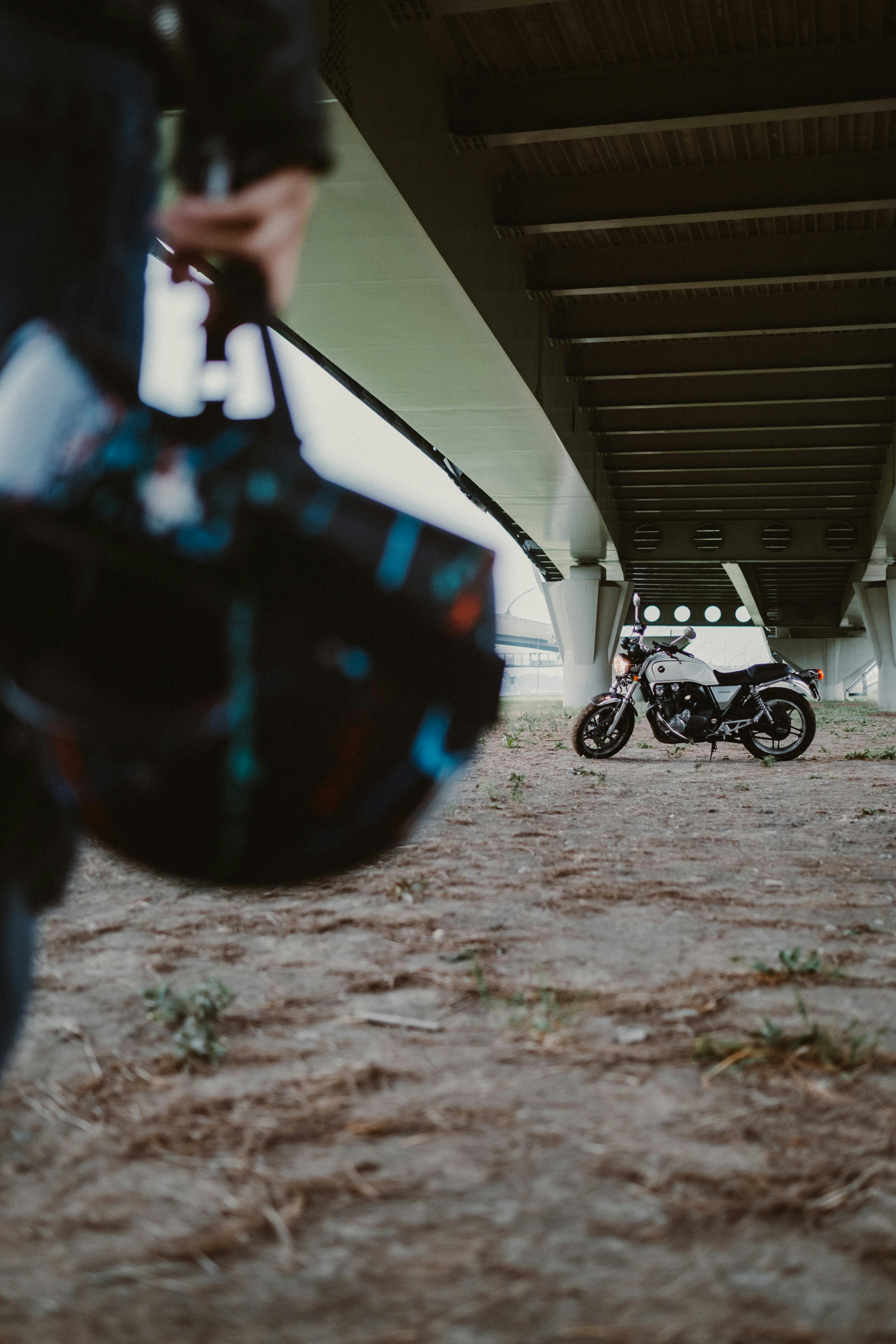 桥下停着一辆摩托车，前景是头盔