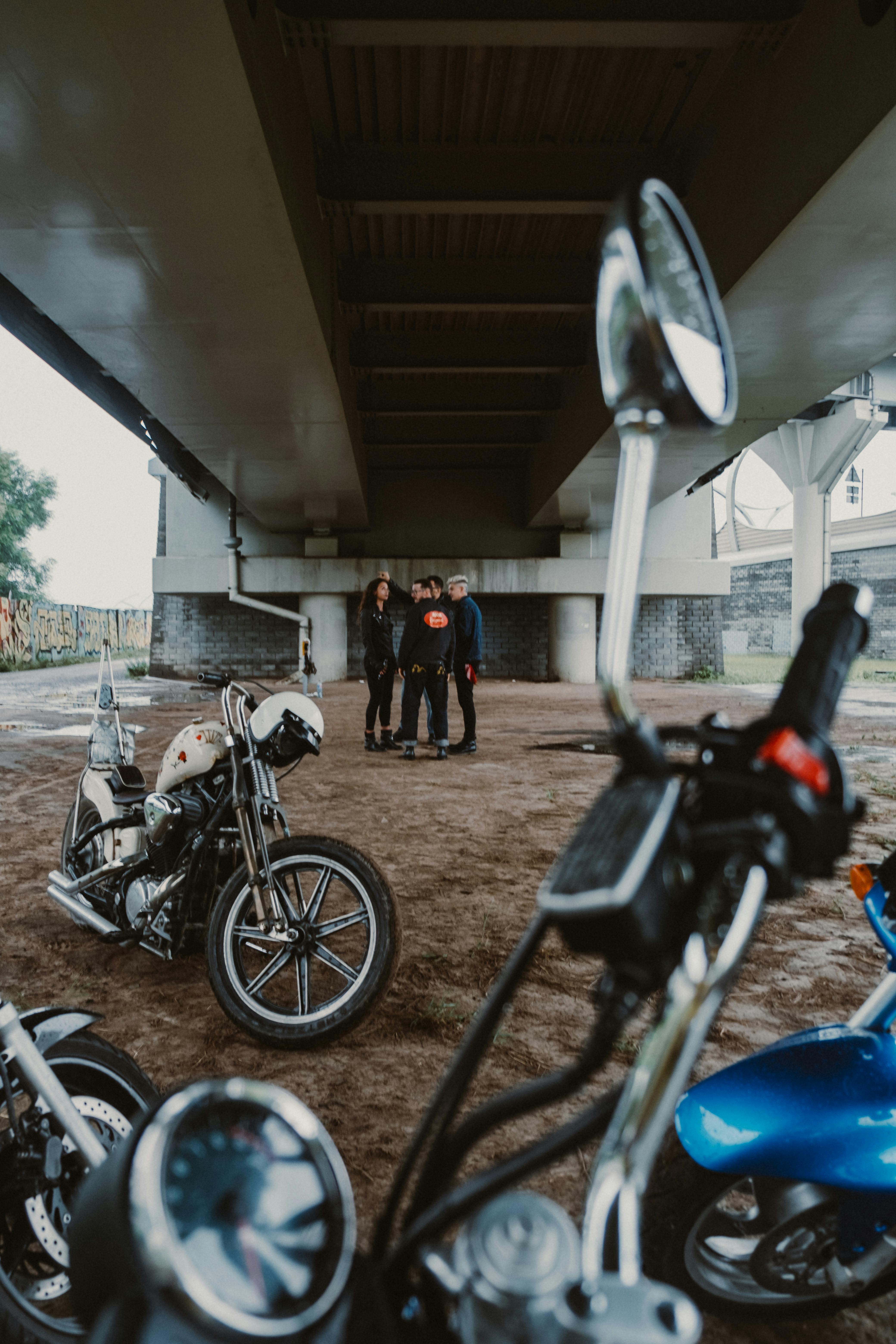 一群人在一座现代城市桥下骑着摩托车聚集