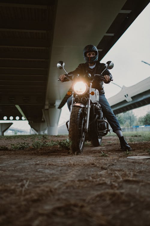 Man in Black Leather Jacket Riding Motorcycle With Helmet