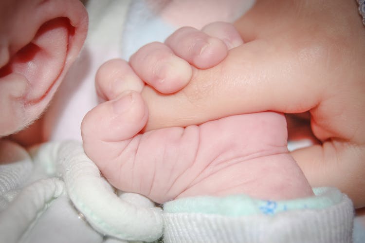 Crop Sleeping Newborn Baby Grasping Parents Finger