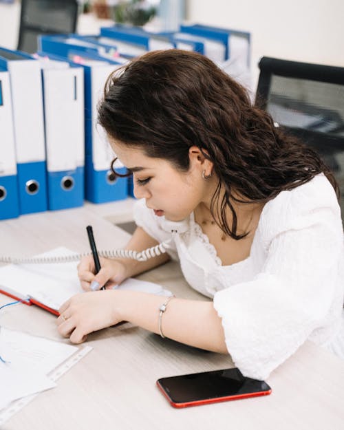 Gadis Berkemeja Putih Menulis Di Kertas Putih