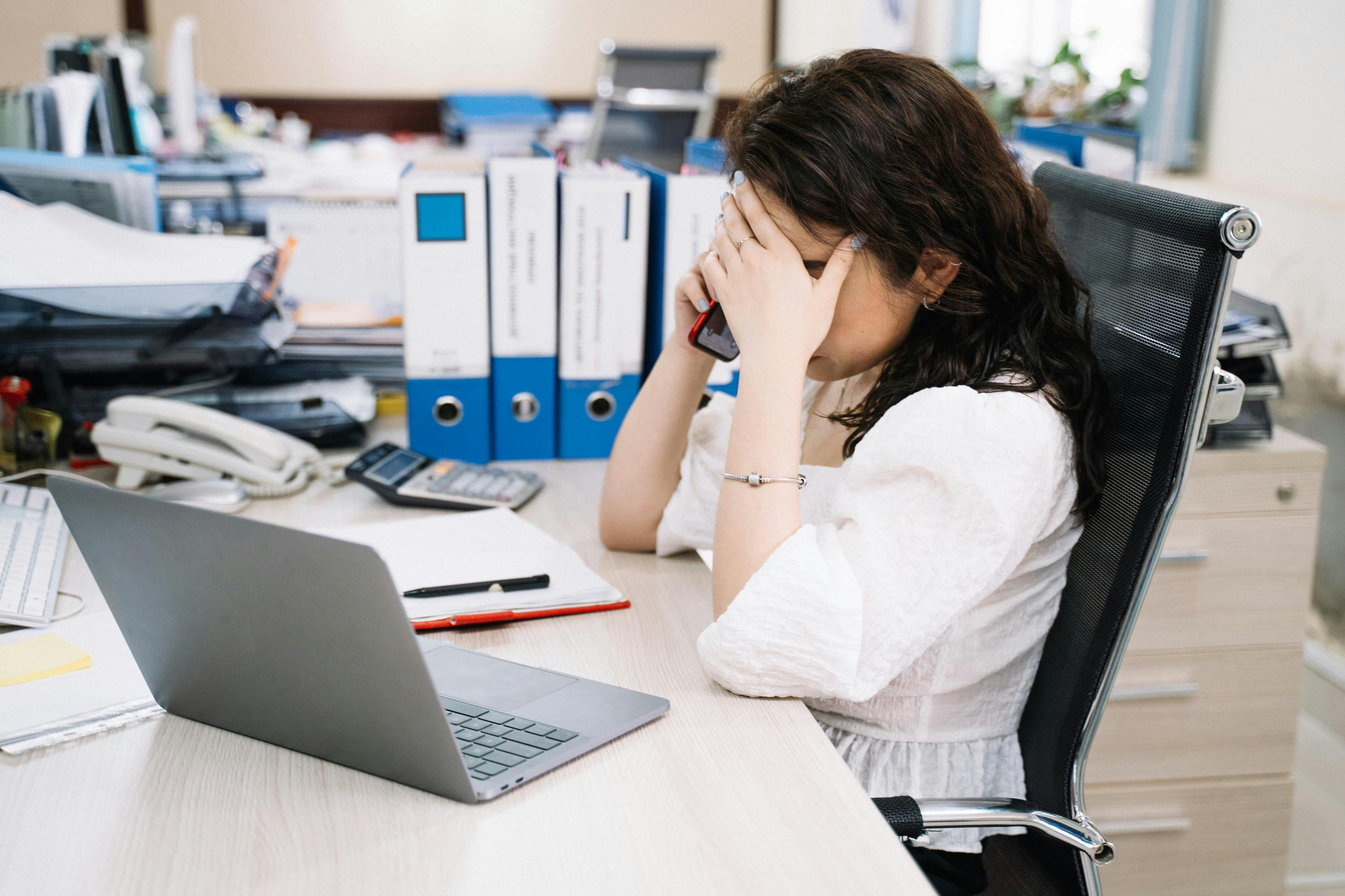 woman sitting behind her desk having a telephone call