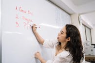 Woman Writing a Plan on the Board