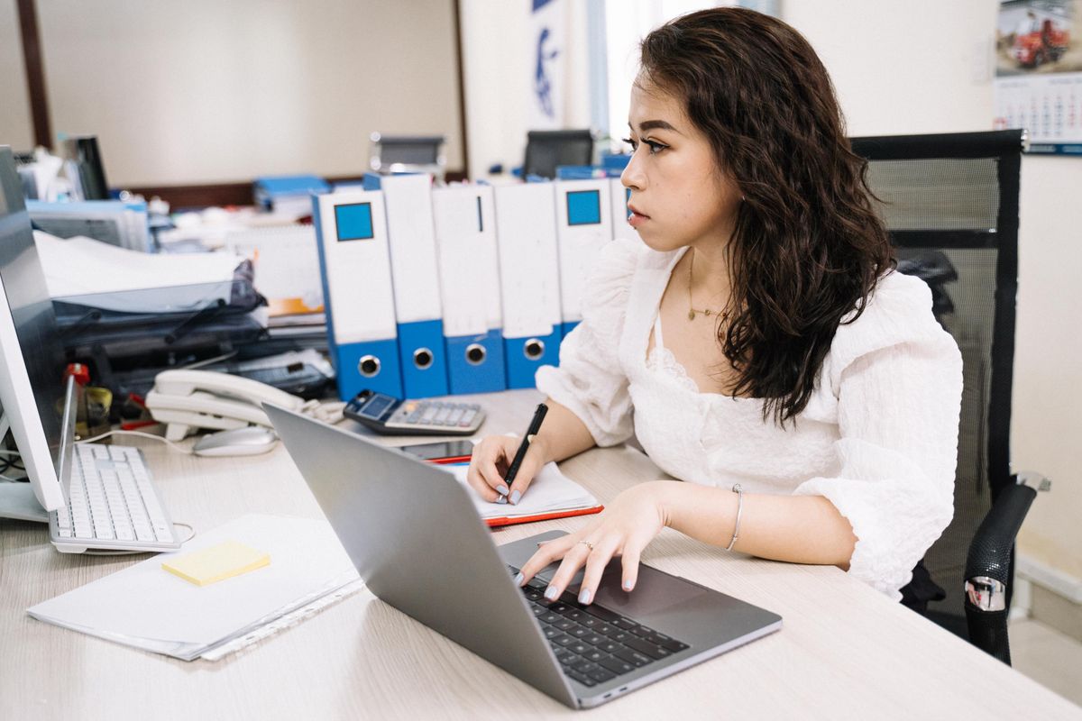 Une personne saisit des données administratives sur un ordinateur portable dans un bureau organisé