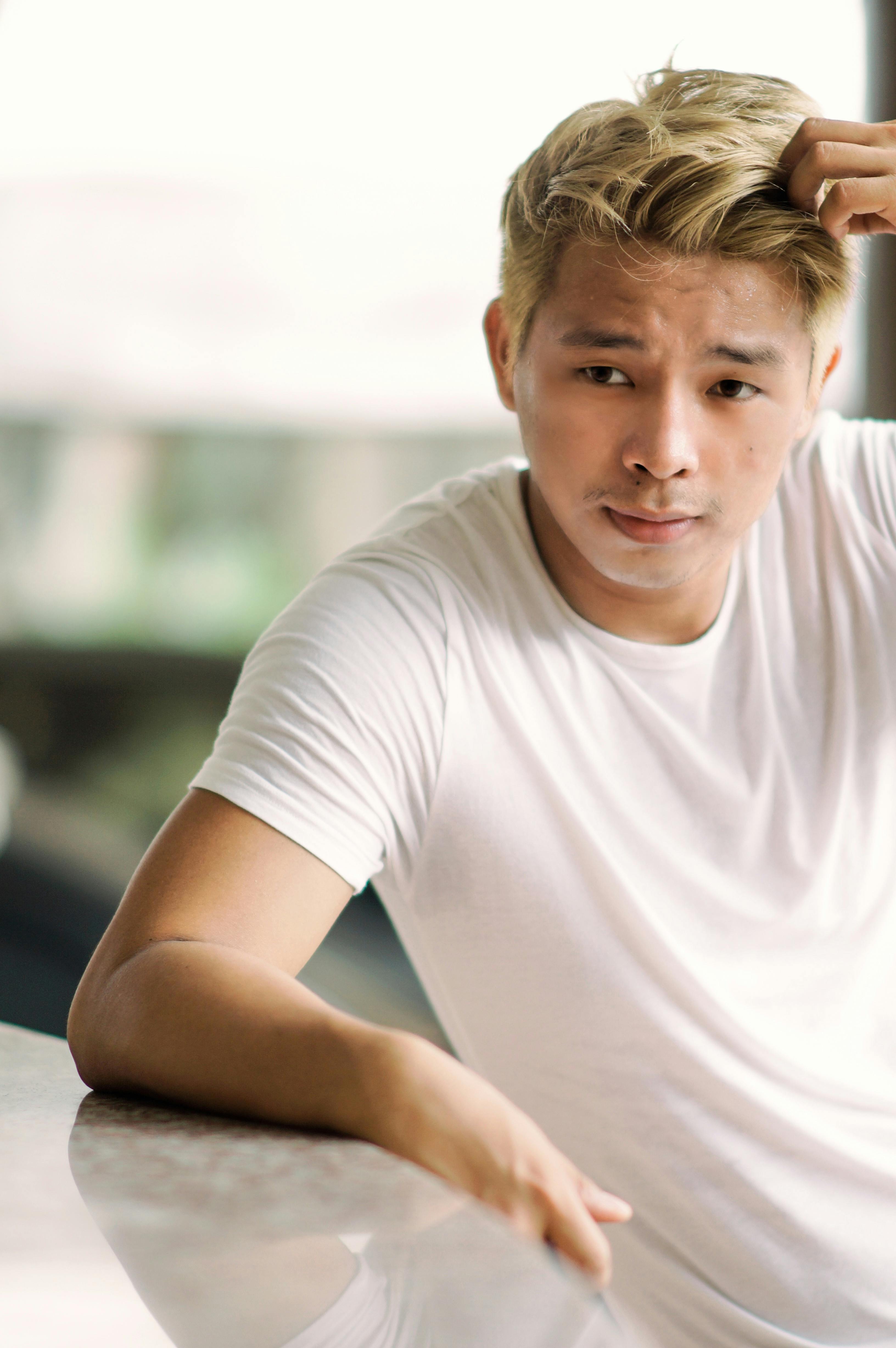 A Pensive Young Man Sitting On Wooden Chair By The Table · Free Stock Photo