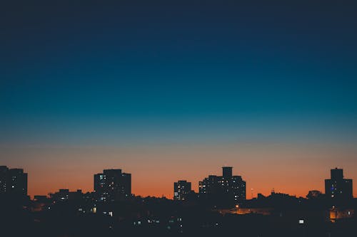 Sundown sky over city buildings silhouettes