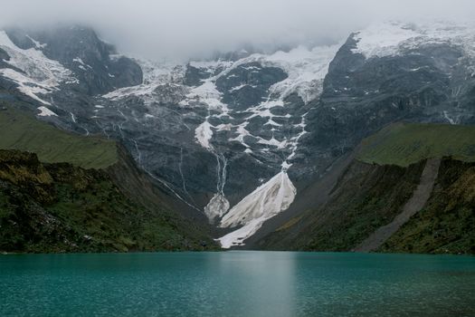 碧绿的秘鲁湖中，倒映着白雪皑皑的安第斯山脉的宁静景色
