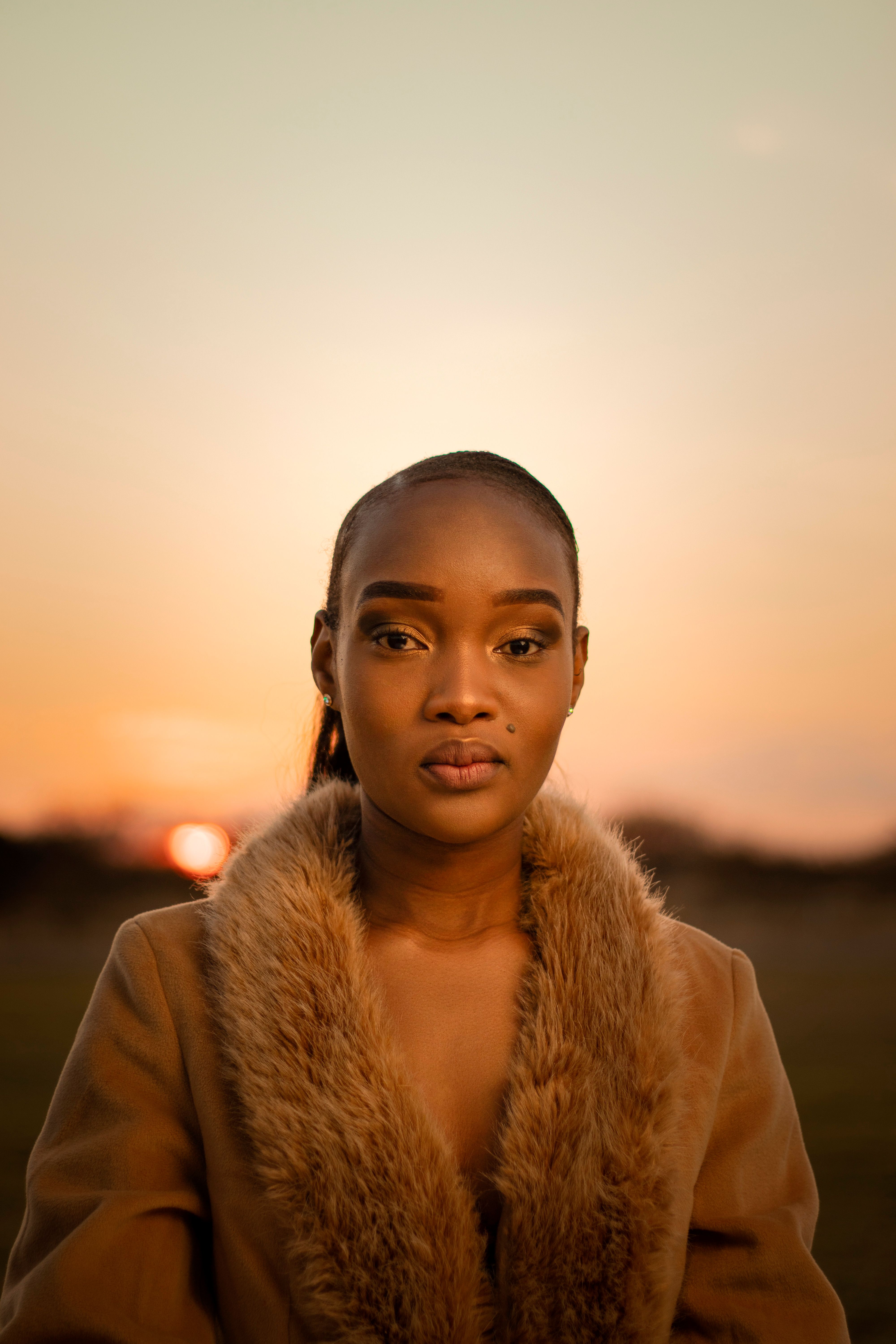 Stunning portrait of a woman in fur-lined coat captured during a warm sunset in Palapye.