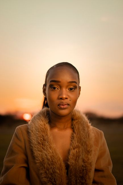 Stunning portrait of a woman in fur-lined coat captured during a warm sunset in Palapye.
