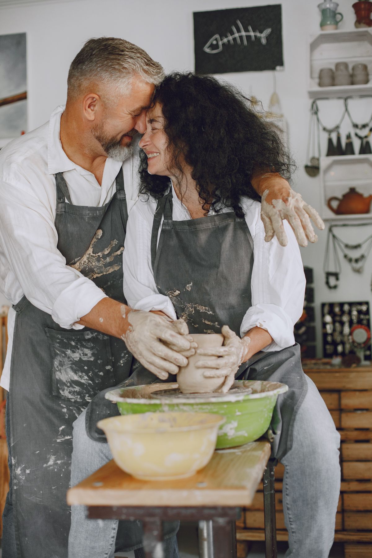 Two makers laughing together at the pottery wheel