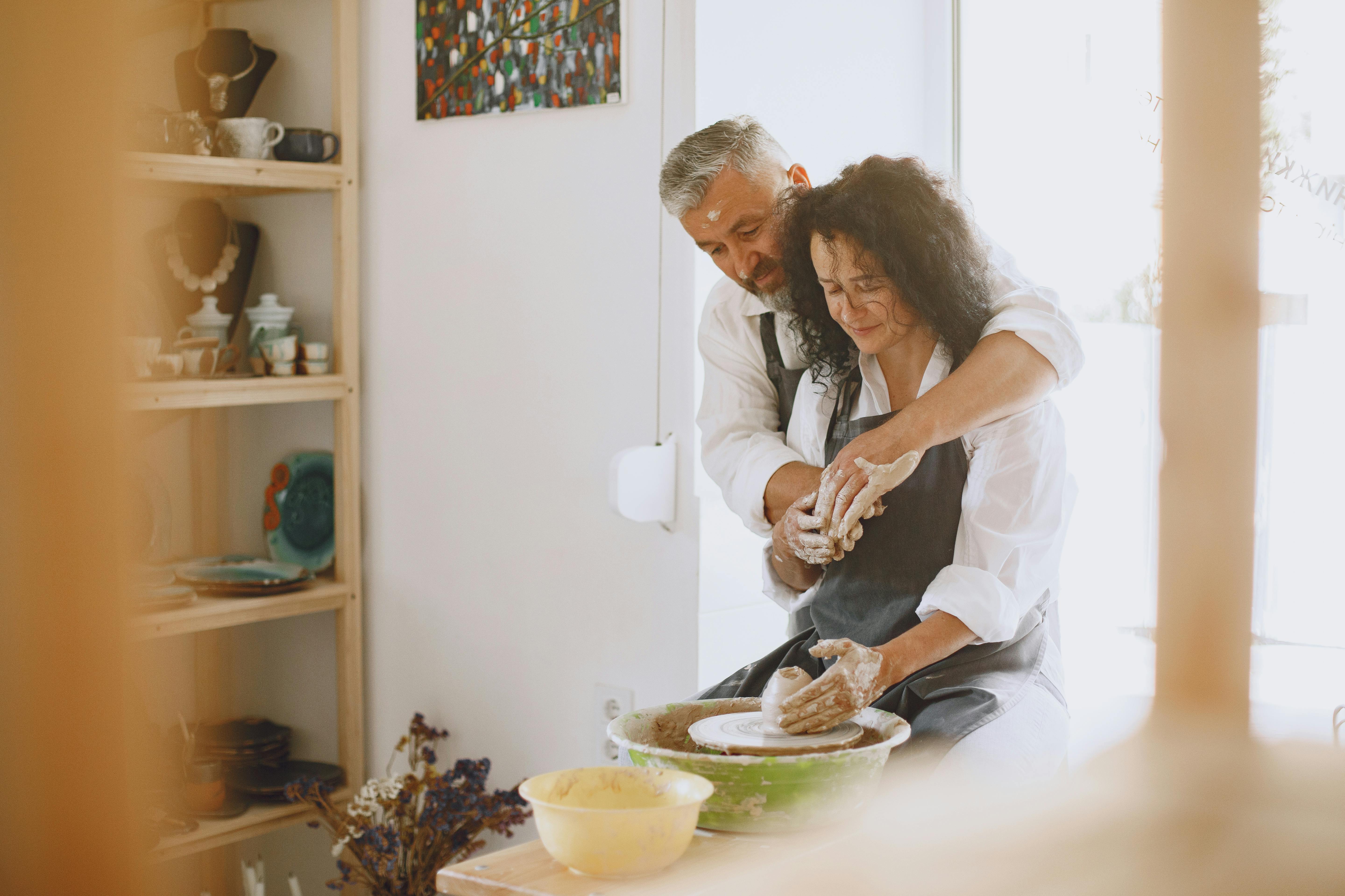 couple wearing aprons doing pottery