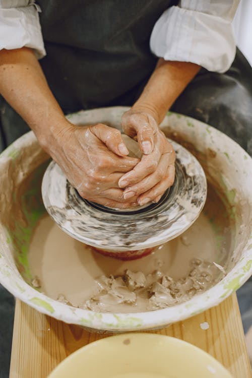 Free Person Making Clay Pot With Brown Powder Stock Photo