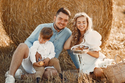 Family Sitting on a Field with an Aluminum Tray of Bread