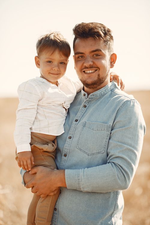 Free A joyful moment of a father embracing his son in an outdoor setting, capturing family love and happiness. Stock Photo