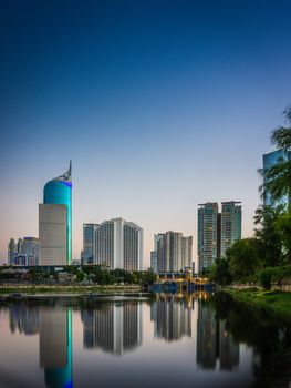 黄昏时分，雅加达天际线的壮丽景色倒映在宁静的水道中