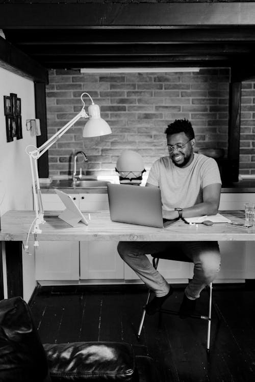 Grayscale Photo of a Man Working From Home