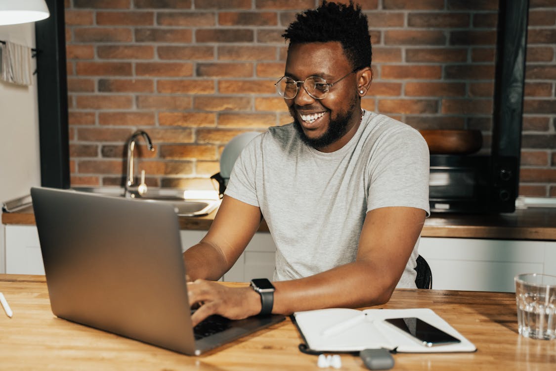 Gratis stockfoto met Afro-Amerikaanse man, afstandswerk, apple laptop Stockfoto