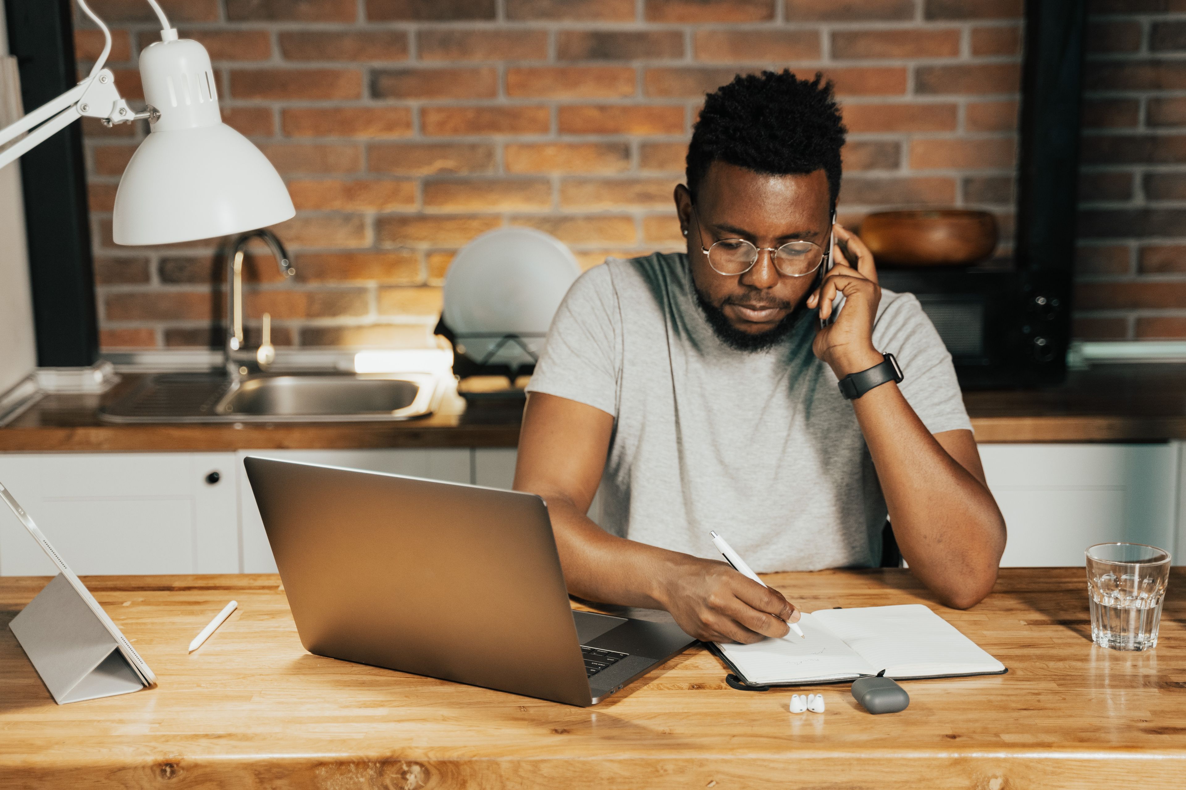 Job seeker drafting a resume on a laptop with handwritten notes beside the keyboard
