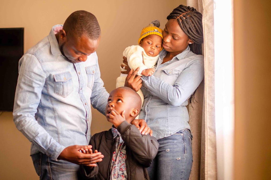 Father and Son Standing Beside Mother and Baby