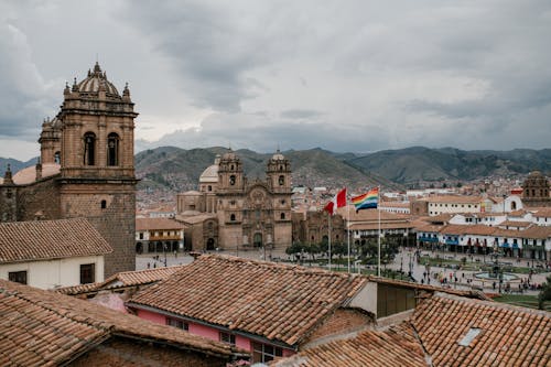 ペルーのクスコにある中世の教会と古い瓦屋根の家々の街並み