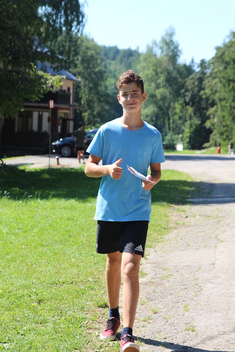 Teenage Boy In Blue Shirt Walking In The Street