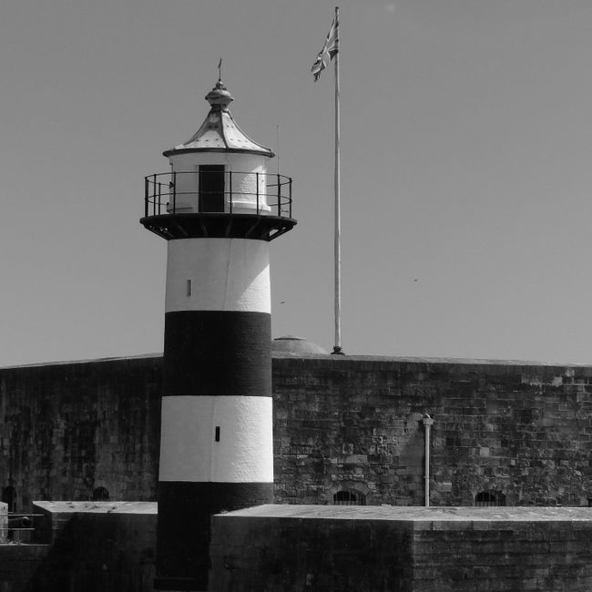 Black and white image of Southsea Castle lighthouse with flag, Portsmouth, UK.