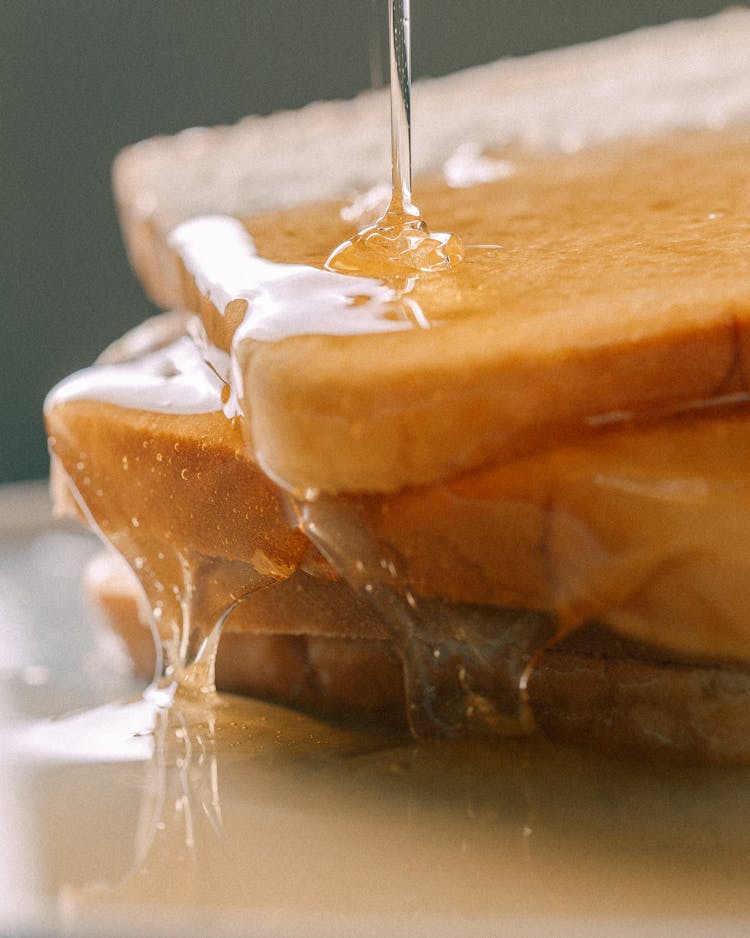 Pouring Honey On A Stack Of Toast