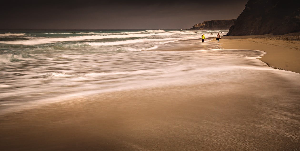 People Walking on Seashore beside the Beach