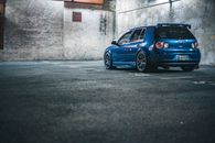 Blue car parked near wall
