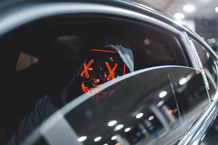 Anonymous Man In Mask Sitting In Car