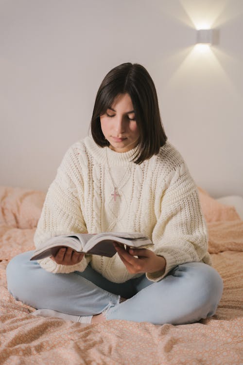 Woman in White Sweater Sitting Reading