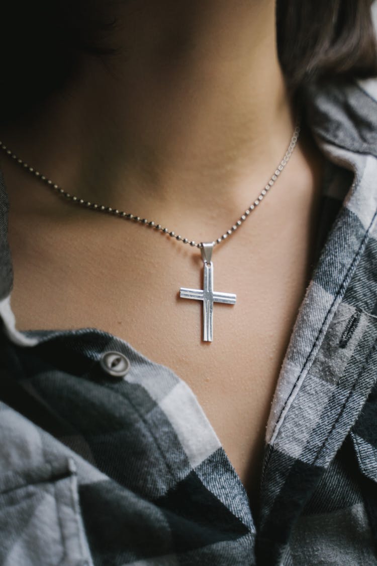 A Person Wearing A Cross Necklace