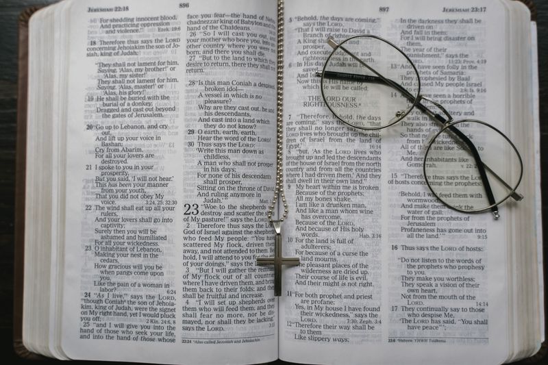 Open Bible with a cross necklace and eyeglasses