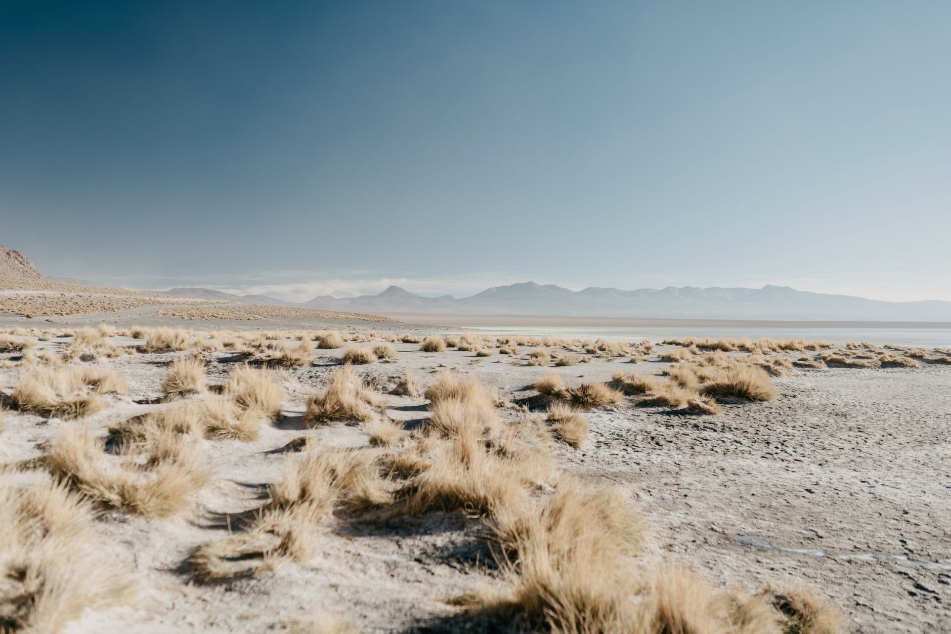 Scenery of barren vast valley covered with random dry grass located in mountainous terrain