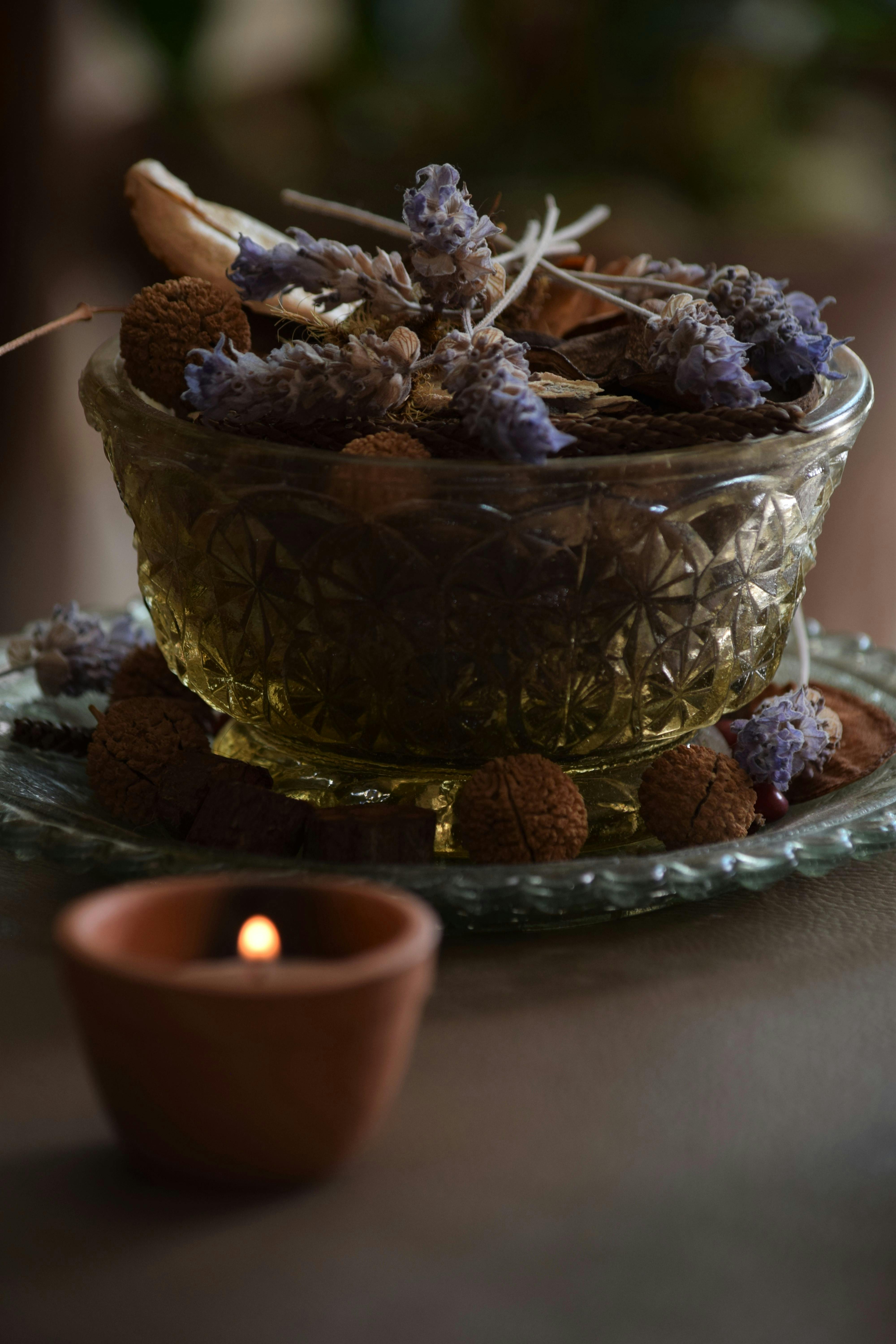 在柔和而富有情调的灯光下，一个宁静的静物摆放着薰衣草、坚果和蜡烛