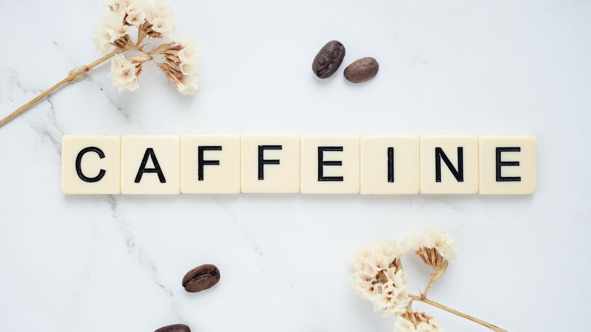 Unleash Energy with Modafinil: Your Ultimate Guide Scrabble tiles spelling caffeine with coffee beans on marble background.