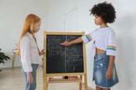Diverse schoolgirls learning math in cozy room