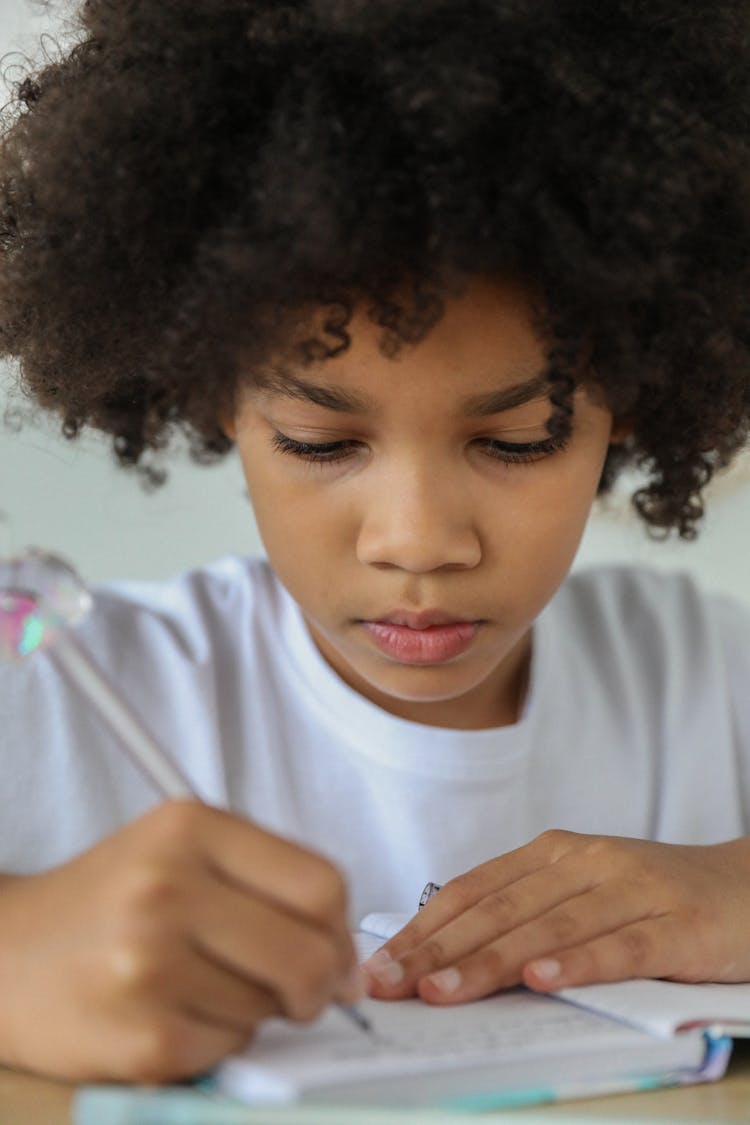 Crop Black Schoolchild Doing Homework At Table