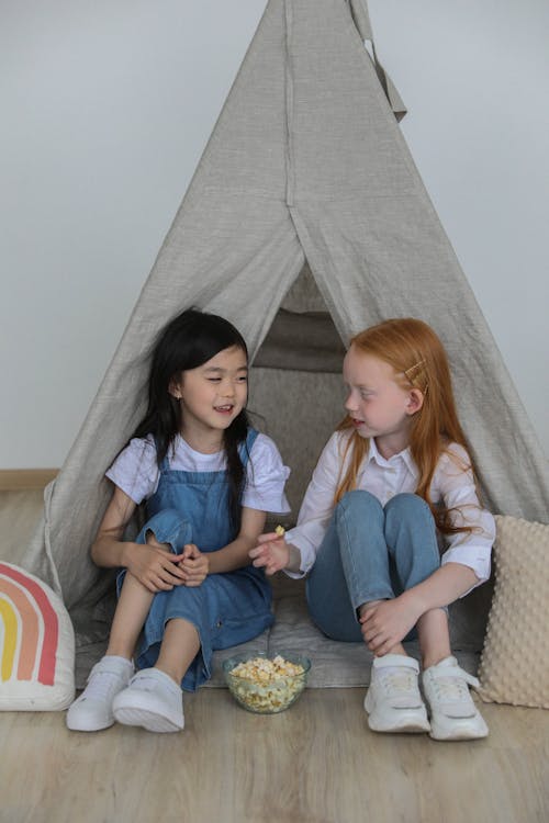 Lächelnde Verschiedene Mädchen Mit Popcorn Nahe Kinderzelt