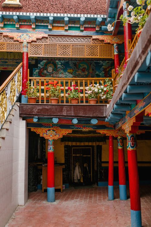 Free Facade of traditional building located on terrace in street with potted plants near fence and stairway with colorful ornamental columns Stock Photo