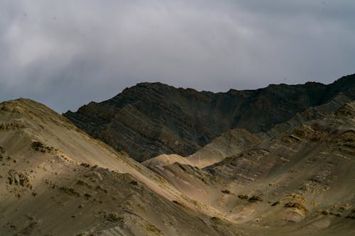 Stone valley with uneven surface located in mountainous area against cloudy sky in nature in overcast weather on summer day